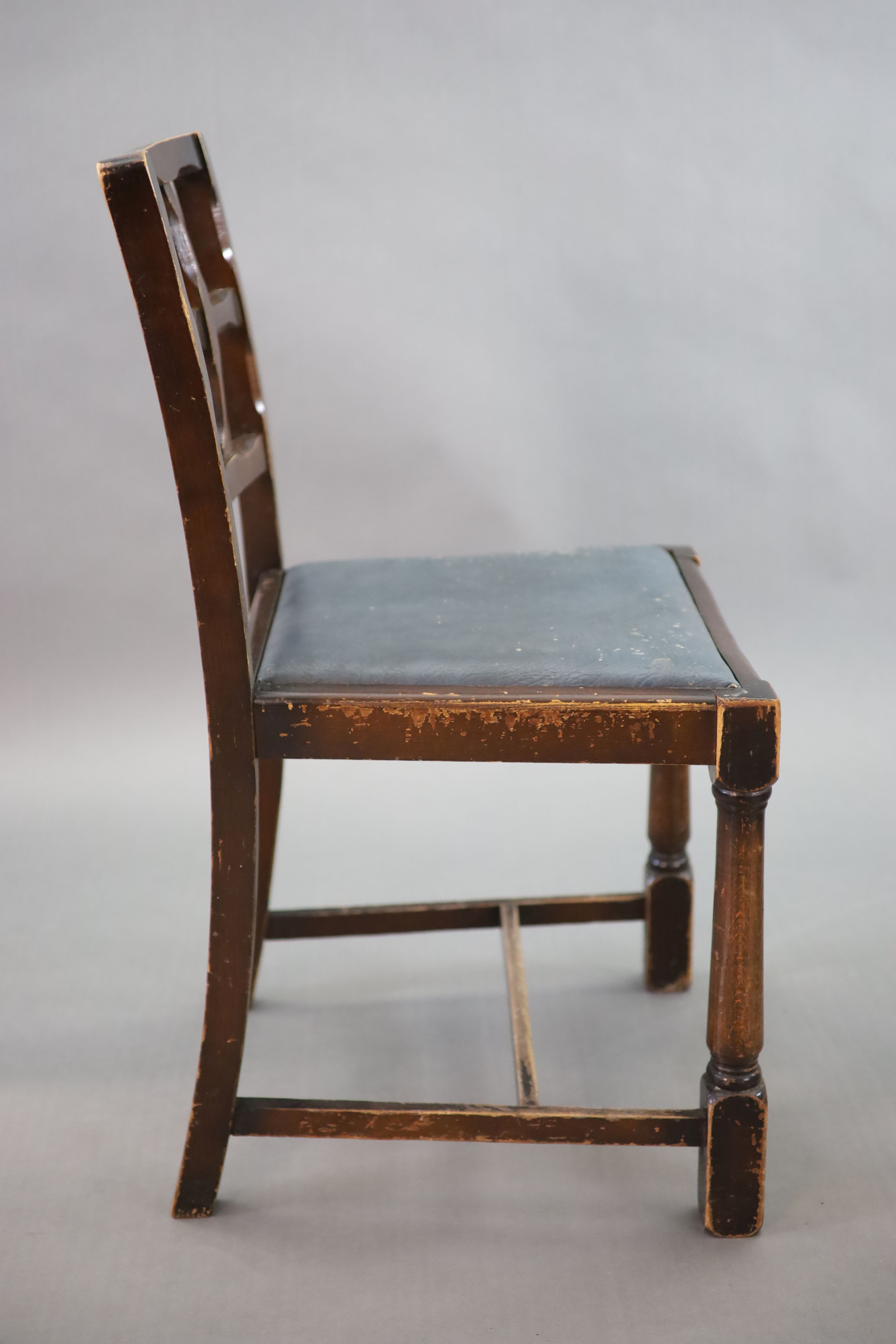 A set of twelve stained beech and oak dining chairs, with cross frame backs and drop-in seats, on turned and squared legs